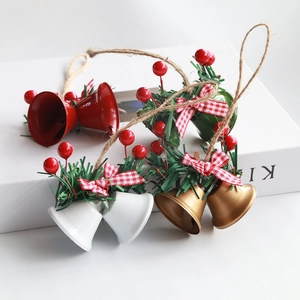 Close-up of festive Christmas bell ornaments with pine needles and plaid bows