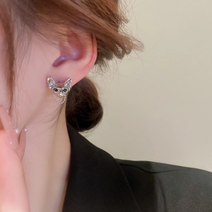 Detailed view of silver fox-shaped stud earrings with dark gems and a delicate chain