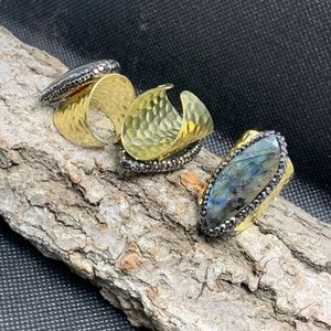 Detailed macro view of wide golden ring with marquise labradorite stone and hammered metal