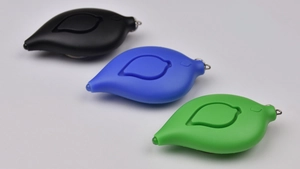 Leaf-shaped personal safety alarms in black, blue, and green with LED lights and keychains