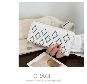 Detailaufnahme der weißen Leder-Clutch mit grauen Nieten und Rautenmuster-Design