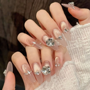 Macro detail of champagne cat-eye almond press-on nails with luxury 3D crystal rhinestones