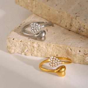 Detailed view of silver and gold heart-shaped stainless steel rings with rhinestones