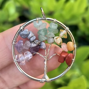 Close-up of colorful natural stone tree of life pendant with silver wire-wrapped details