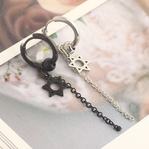Macro shot of black and silver stainless steel earrings with star charms and long chains