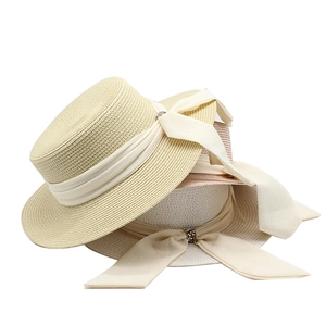 Detail of stacked straw hats showing fine weaving, ribbon bows and rhinestone buckles