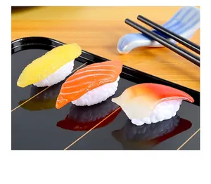 Realistic PVC sushi models featuring salmon and fish roe on a black glossy tray
