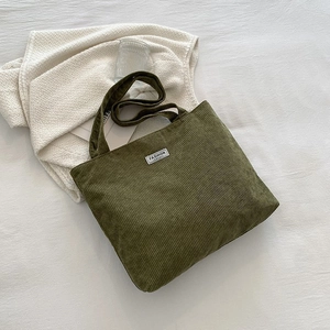 Detail of dark green corduroy tote bag with high-capacity design and textured fabric