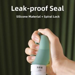 Close-up of hand squeezing flexible green silicone travel bottle for leakproof liquid soap