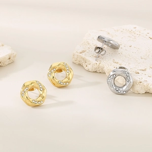 Detailed macro view of 18K gold and silver hexagon twisted earrings with pavé crystals
