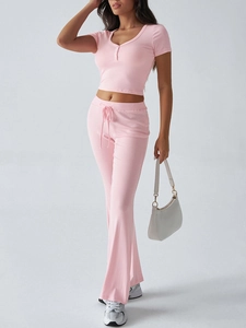 Dettaglio del top rosa Y2K a maniche corte con scollo a V e pantaloni dritti con lacci