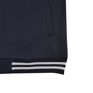 Dettaglio dell'orlo a costine con strisce bianche e tasca laterale su giacca blu navy