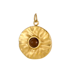 Detailed close-up of a vintage golden round pendant with a central brown gemstone inlay