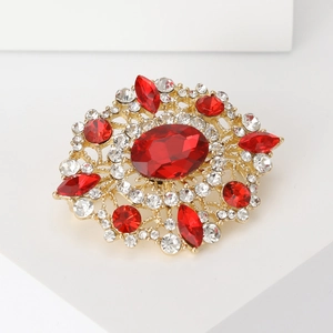 Macro shot of oval vintage brooch with red and white crystals on a white display stand