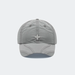 Gros plan sur la casquette grise avec broderie en croix et coutures froissées uniques