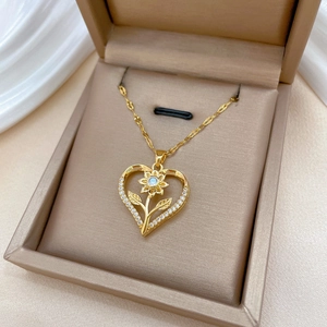 Gold heart-shaped sunflower necklace with sparkling crystals in a beige jewelry box