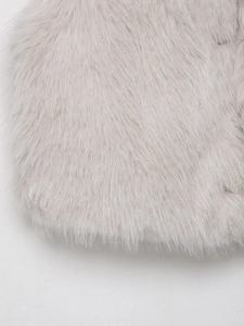 Nahaufnahme der weichen flauschigen Kunstfelltextur in Cremeweiß aus Plüschmaterial