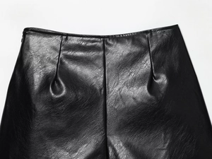 Détail du short en similicuir noir à taille haute avec plis texturés et coutures