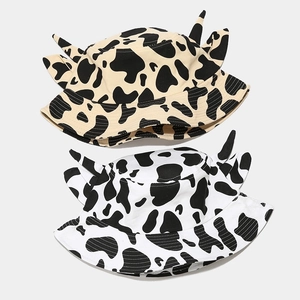 Cow print bucket hat with cute horn ears in black and white pattern for outdoor sun protection