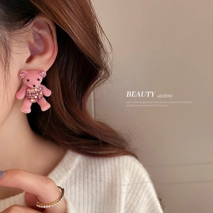 Pink flocked teddy bear earrings with rhinestones shown on a model in a side profile view