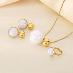 Detail view of 18K gold plated jewelry set with iridescent pearls on a soft fabric base