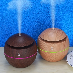 Dual mushroom-style wood grain ultrasonic humidifiers emitting mist on a desk