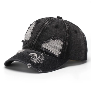 Gros plan des détails usés et des trous sur une casquette de baseball en jean noir