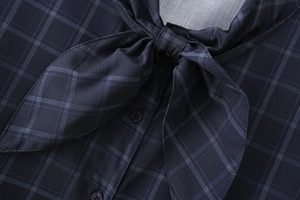 Dettaglio camicia in popeline a quadri blu scuro con colletto a fiocco e bottoni