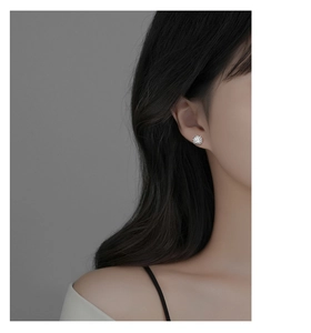 Detailed view of S925 silver stud earrings with shimmering micro-paved cubic zirconia stones