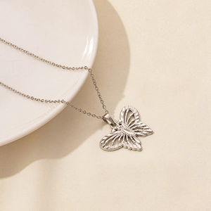 Detailed close-up of a silver hollow butterfly pendant on a stainless steel chain link