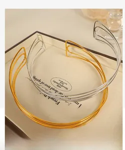 Detailed view of gold and silver C-shaped woven metal collar necklaces in a jewelry tray