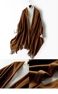 Close-up of brown wool blend shawl with fringe details on a white turtleneck sweater