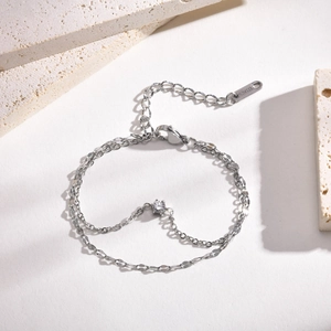 Close-up of silver stainless steel double chain bracelet with a clear zircon stone