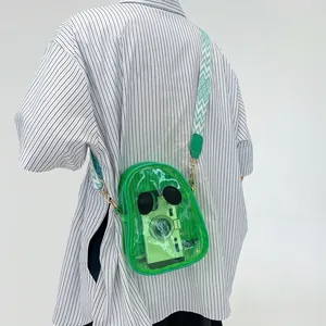 Detail of green transparent PVC jelly bag featuring ghost face design and woven strap