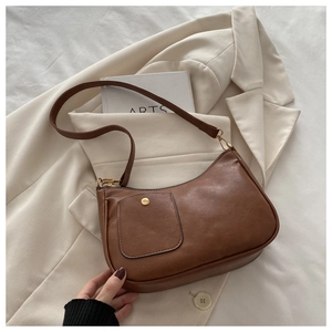 Detailed view of the front flap pocket with gold snap on a brown vintage hobo bag