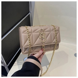 Detailed close-up of a quilted beige crossbody bag featuring a golden SS logo and fringe