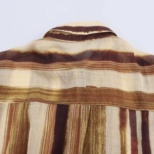 Gros plan des rayures marron et beige sur le tissu léger de la chemise au col