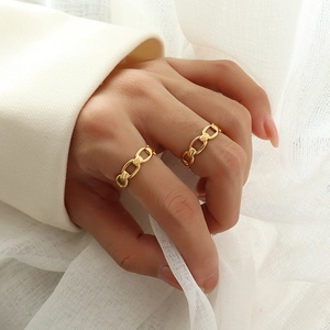 French style gold-plated flat chain rings worn as stacked jewelry on model's fingers