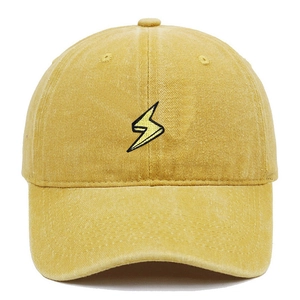 Dettaglio del ricamo a fulmine giallo su un cappellino in cotone lavato vintage