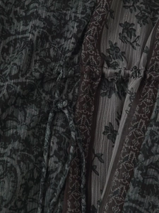 Detail aus Metallic-Seidenstoff mit V-Ausschnitt und Kordelzug am grauen Blumenkleid