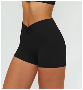 Detail of high-waist black yoga shorts featuring a V-shaped crossover pleated waistband