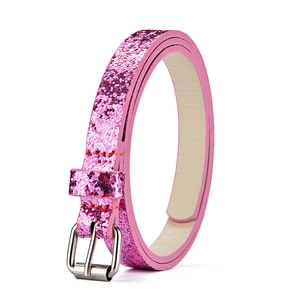 Primo piano dettagliato della cintura per bambini glitterata rosa con fibbia in metallo.