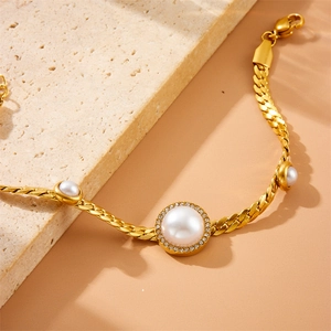 Golden snake chain bracelet featuring a central pearl surrounded by diamonds and side pearls