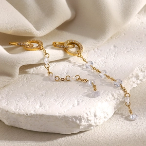 Macro detail of 18K gold plated long tassel earrings with sparkling zircon accents