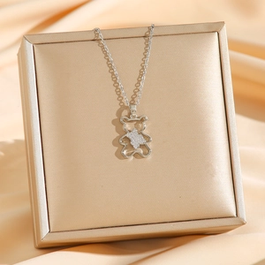 Collier en acier titane avec pendentif ours évidé et diamants sur présentoir en soie
