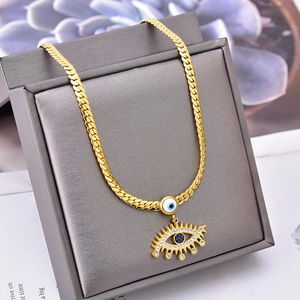 Collier chaîne serpent dorée avec pendentif oeil bleu brillant sur boîte en cuir