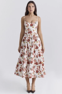 Detail of red floral print on white backless midi dress with delicate spaghetti straps