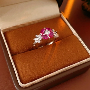 Close-up of vintage flower ring with red oval gemstones in a velvet jewelry box