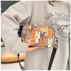 Detail of cartoon bunny crossbody bag showing nylon strap and printed canvas texture