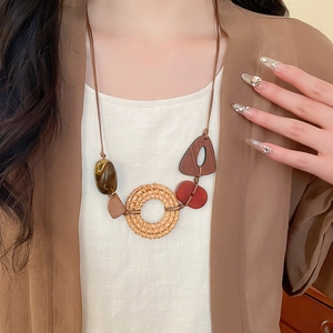 Detail of bohemian necklace with rattan hoop, marble resin bead and wooden elements